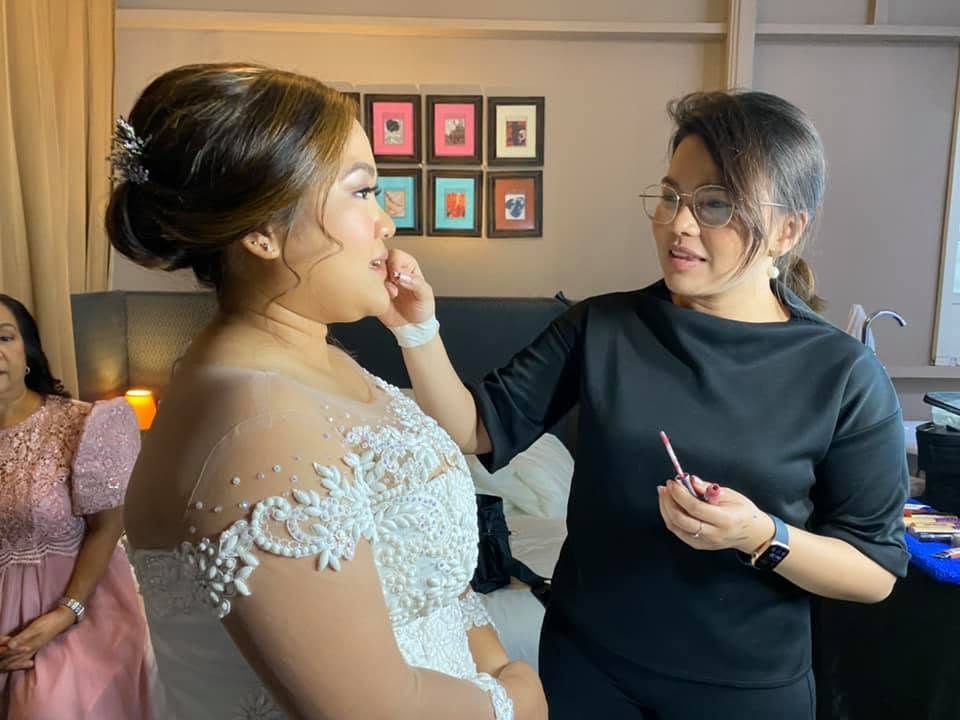 Dane touching up a bride&rsquo;s makeup